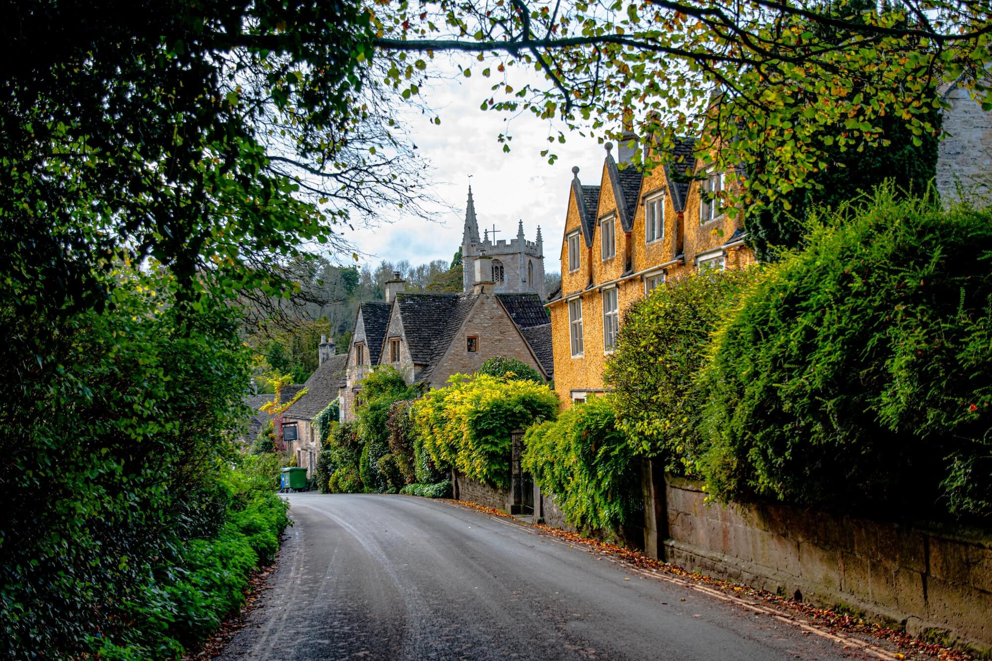View along a leafy lane towards St Andrew's Church, Castle Combe